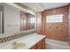 Bathroom featuring white countertop, tiled walls, a large mirror, and a shower/tub combo at 3093 S Horizon Pl, Oviedo, FL 32765