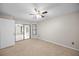 Bright bedroom featuring neutral carpeting, a window, and sliding door leading to the sunroom at 3093 S Horizon Pl, Oviedo, FL 32765