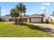 Charming brick home featuring a two-car garage and lush, green lawn with palm trees at 3093 S Horizon Pl, Oviedo, FL 32765