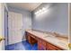 Well lit bathroom with blue walls, and double vanity sinks with granite countertops and dark wood cabinets at 321 Cape Sable Dr, Orlando, FL 32825