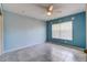 This light blue bedroom features neutral tile flooring, a ceiling fan, and a large window for natural light at 321 Cape Sable Dr, Orlando, FL 32825