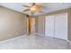 Bedroom featuring neutral tile flooring, a ceiling fan, and a closet, offering functionality and comfort at 321 Cape Sable Dr, Orlando, FL 32825