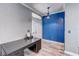 Bright entryway featuring gray walls, blue accent wall, white door, gray wood-look tile flooring, and dark desk at 321 Cape Sable Dr, Orlando, FL 32825