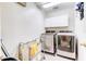 Laundry room with front load washer and dryer, storage cabinets, and tiled floors at 321 Cape Sable Dr, Orlando, FL 32825