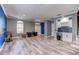 Open-concept living room featuring gray walls, blue accent wall, decorative wall, white trim, and gray wood-look tile flooring at 321 Cape Sable Dr, Orlando, FL 32825