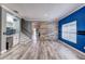 Open-concept living room featuring gray walls, blue accent wall, decorative wall, white trim, and gray wood-look tile flooring at 321 Cape Sable Dr, Orlando, FL 32825