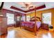 Spacious main bedroom featuring a tray ceiling, hardwood floors, and matching furnishings at 321 Cape Sable Dr, Orlando, FL 32825