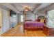 Spacious main bedroom featuring a four-poster bed, wood floors, trey ceiling, and ample natural light at 321 Cape Sable Dr, Orlando, FL 32825