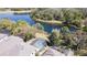 A serene aerial view showcases a screened-in pool and lush backyard of a private residence near a tranquil lake at 321 Cape Sable Dr, Orlando, FL 32825