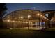 Back exterior view of a screened-in pool house with string lights, overlooking a grassy lawn at dusk at 321 Cape Sable Dr, Orlando, FL 32825