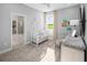 Well-lit Bedroom featuring a white crib and changing table with patterned curtains at 3526 Douglas Fir Dr, Apopka, FL 32703