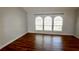 Living room features three arched windows bringing in lots of natural light and wood-look flooring at 3548 Picciola Cutoff Rd, Fruitland Park, FL 34731