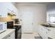 Well-lit kitchen featuring white cabinets, modern appliances, and access to living area at 3605 Conroy Rd # 537, Orlando, FL 32839