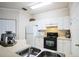 Well-lit kitchen featuring white cabinets, black appliances, and stainless steel dual sink at 3605 Conroy Rd # 537, Orlando, FL 32839