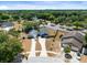 Aerial view showcasing a home with a large driveway, beautiful landscaping, and surrounding mature trees at 4458 Goldenrain Ct, Orlando, FL 32808