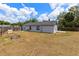 Spacious fenced backyard with a gray house and a small shed and planter box, perfect for outdoor enjoyment at 4458 Goldenrain Ct, Orlando, FL 32808