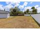 Large backyard enclosed by a fence and white wall, offering privacy and ample space for various activities at 4458 Goldenrain Ct, Orlando, FL 32808