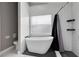 Modern bathroom featuring a soaking tub with black fixtures, a separate toilet, and tiled floors and walls at 4458 Goldenrain Ct, Orlando, FL 32808