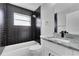 Modern bathroom showcasing black tiled shower, sleek white vanity with granite countertop, and modern fixtures at 4458 Goldenrain Ct, Orlando, FL 32808