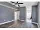 Large bedroom with wood-look floors, ceiling fan, and entry to a brightly lit bathroom with a modern soaking tub at 4458 Goldenrain Ct, Orlando, FL 32808