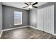 Cozy bedroom with a ceiling fan, wood flooring, and a double-door closet at 4458 Goldenrain Ct, Orlando, FL 32808