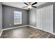 This spacious bedroom features wood-look flooring, a modern ceiling fan, and a large window with natural light at 4458 Goldenrain Ct, Orlando, FL 32808