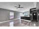 Spacious living room featuring gray wood-look floors, a window, and an open floorplan with granite kitchen counter seating at 4458 Goldenrain Ct, Orlando, FL 32808