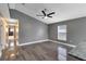 Bright living room featuring gray wood-look floors, a window, and connecting hallway to a modern bathroom at 4458 Goldenrain Ct, Orlando, FL 32808