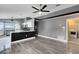 Spacious living room featuring gray wood-look floors, ceiling fans, and kitchen with stainless steel appliances at 4458 Goldenrain Ct, Orlando, FL 32808