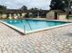 Sparkling community pool is surrounded by brick pavers, lounge chairs, and mature landscaping at 482 Windmeadows St # 482, Altamonte Springs, FL 32701