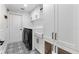 Laundry room with black and white patterned floors, white cabinetry, sink and black washer and dryer at 5215 Phillips Oaks Ln, Orlando, FL 32812