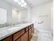 This bathroom features a double vanity with granite countertop and neutral color palette at 5647 Barletta Dr, St Cloud, FL 34771