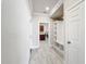 Hallway with tile floors, neutral paint, and a view into the laundry room at 5647 Barletta Dr, St Cloud, FL 34771