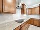 Modern kitchen with stainless hood, white backsplash, granite countertops, and wood cabinetry at 5647 Barletta Dr, St Cloud, FL 34771