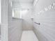 Walk-in shower featuring light gray tile, a glass panel and a handrail at 5647 Barletta Dr, St Cloud, FL 34771