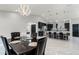 Open dining area with modern chandelier adjacent to the contemporary kitchen and breakfast bar, and shiny tile flooring at 645 Riverwoods Cir, Orlando, FL 32825