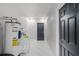 Well-lit laundry room featuring a water heater, utility sink, white floors, and access doors at 645 Riverwoods Cir, Orlando, FL 32825