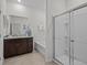 Modern bathroom with a glass shower, a large mirror, and a dark brown vanity at 7805 Oak Reflection Loop, Davenport, FL 33837