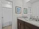 Bathroom featuring a double vanity with granite counters and shower with curtain at 7805 Oak Reflection Loop, Davenport, FL 33837