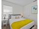 Bright bedroom featuring a queen bed with yellow throw and side tables, with art accents at 7805 Oak Reflection Loop, Davenport, FL 33837