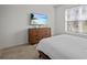 Bright bedroom featuring a dresser with a mounted TV and a large window at 7805 Oak Reflection Loop, Davenport, FL 33837