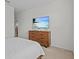 Bedroom featuring a wooden dresser and mounted TV, bathed in natural light at 7805 Oak Reflection Loop, Davenport, FL 33837