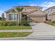 Inviting two-story home featuring a tile roof, manicured lawn, and an attached two-car garage at 7805 Oak Reflection Loop, Davenport, FL 33837