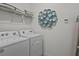 Laundry area with stacked white towels, wall decor and white appliances at 7805 Oak Reflection Loop, Davenport, FL 33837