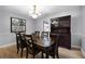 Elegant dining room with hardwood floors, chandelier, and a large dark wood dining table with seating for six at 8992 Palos Verde Dr, Orlando, FL 32825