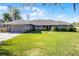 Beautifully landscaped front yard of a gray one-story home with a well-manicured green lawn at 8992 Palos Verde Dr, Orlando, FL 32825