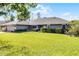 Well-maintained front yard featuring a lush green lawn and neatly trimmed hedges surrounding a gray home at 8992 Palos Verde Dr, Orlando, FL 32825