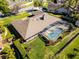 Aerial view of a home with a screened-in pool, well-maintained lawn, and manicured landscaping at 8992 Palos Verde Dr, Orlando, FL 32825