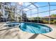 A sparkling pool is surrounded by a screened enclosure and lush greenery for a refreshing oasis at 8992 Palos Verde Dr, Orlando, FL 32825