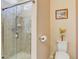 Bathroom boasts tile shower with glass door, modern toilet, and decorative accents at 9673 Sw 63Rd Loop, Ocala, FL 34481